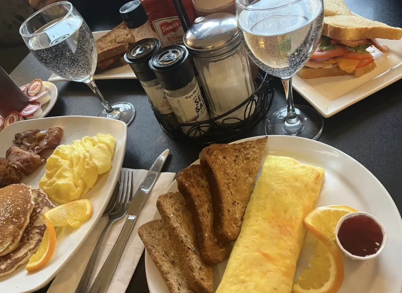 美味しそうな食事の写真。スクランブルエッグとオムレツ。パンケーキやパンがある。