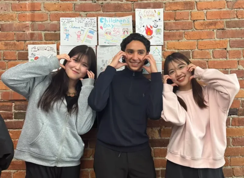 学校でクラスメイトと撮った写真。3人で頬に手を当てたポーズをしている